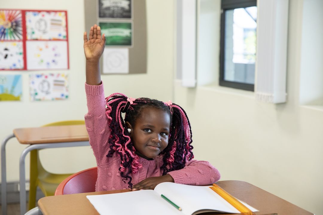 Young Student Raising Hand Enthusiastically in Classroom