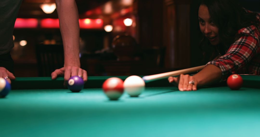Young Woman Playing Pool with Intent Focus in Bar
