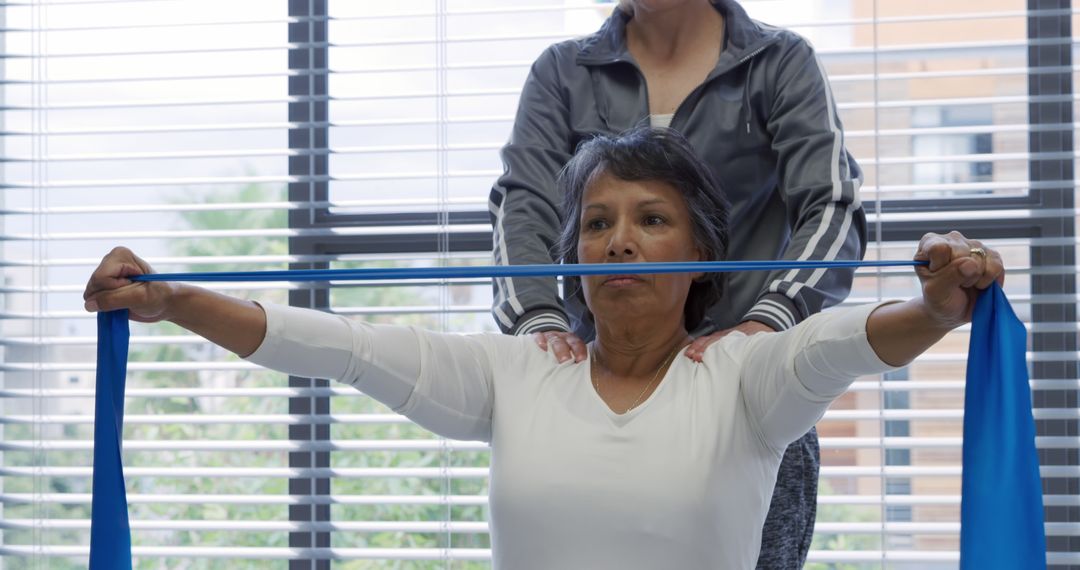 Physical Therapist Assisting Senior Woman with Exercise Band Stretching Routine - Free Images, Stock Photos and Pictures on Pikwizard.com