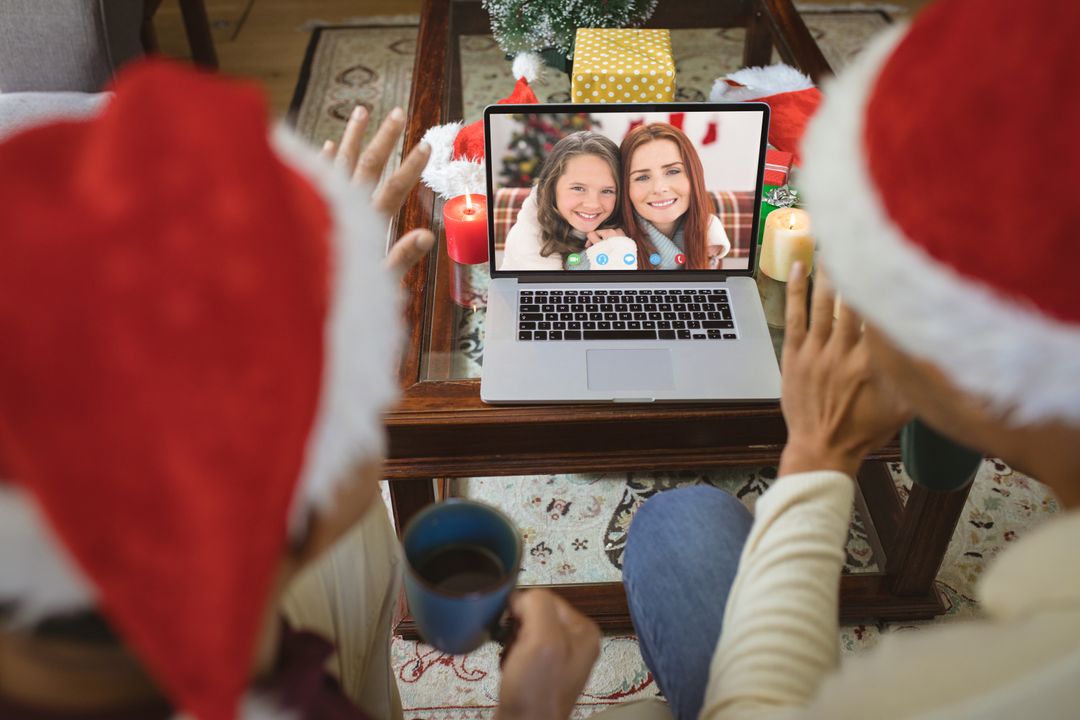 Diverse couple with santa hats having video call with happy caucasian family - Free Images, Stock Photos and Pictures on Pikwizard.com