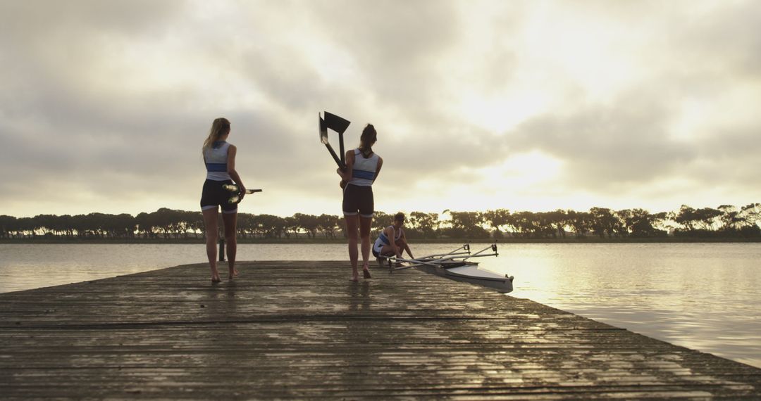 Rowers preparing boat on lake pier at sunrise - Free Images, Stock Photos and Pictures on Pikwizard.com