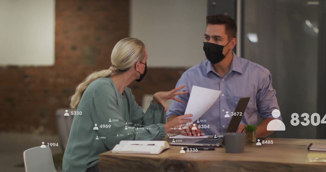 Masked Colleagues Collaborating with Digital Data Overlay at Desk