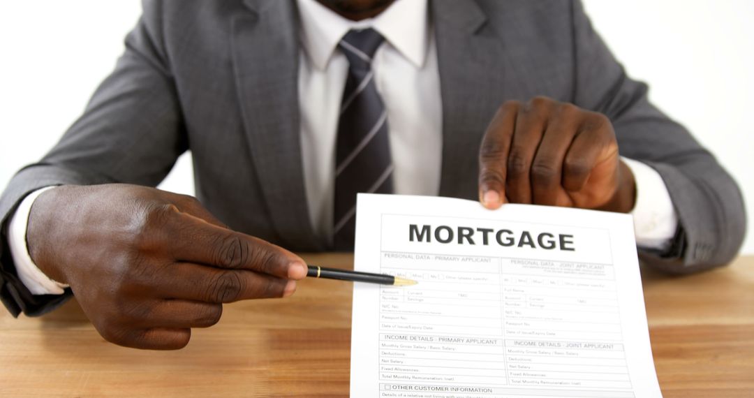 Businessman Holding Pen Pointing to Mortgage Application Form - Free Images, Stock Photos and Pictures on Pikwizard.com