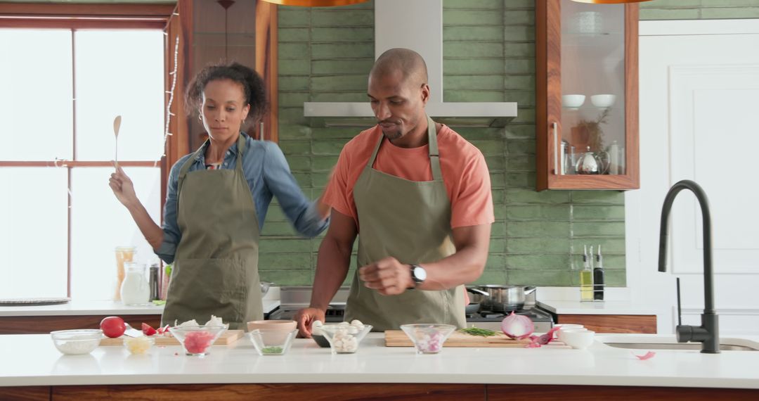 Diverse Couple Enjoying Cooking Together at Home, Dancing and Bonding