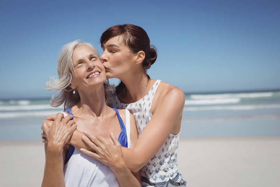 Young woman kissing her mother at beach - Free Images, Stock Photos and Pictures on Pikwizard.com