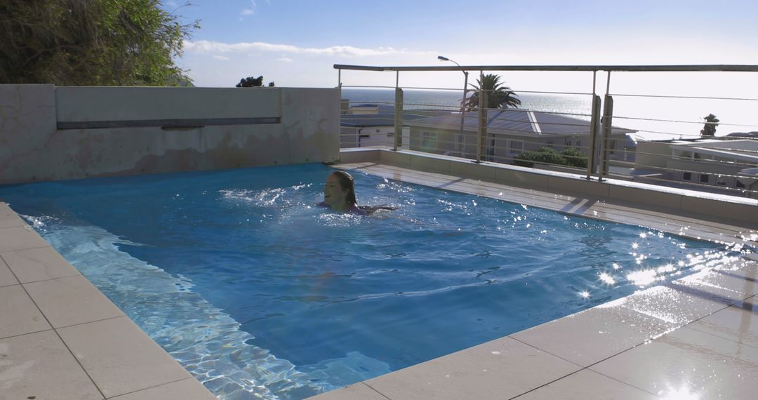 Woman Swimming in Outdoor Pool with Ocean View - Free Images, Stock Photos and Pictures on Pikwizard.com