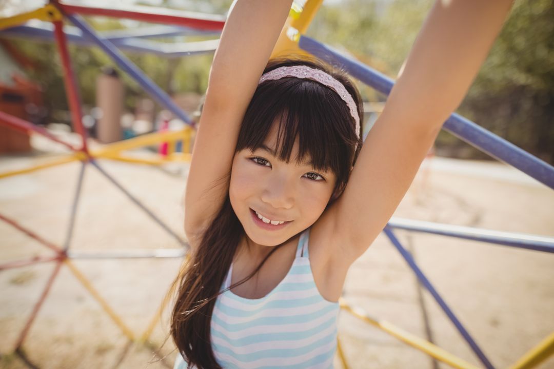 Young Girl Playing on a Colorful Climbing Dome in Playground