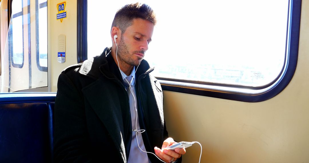 Man Traveling by Metro Train While Listening to Music on Smartphone - Free Images, Stock Photos and Pictures on Pikwizard.com