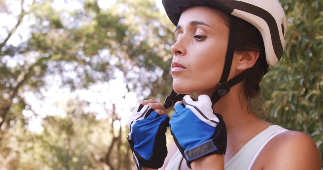 Confident Female Cyclist Adjusting Helmet Strap in Forest - Free Images, Stock Photos and Pictures on Pikwizard.com