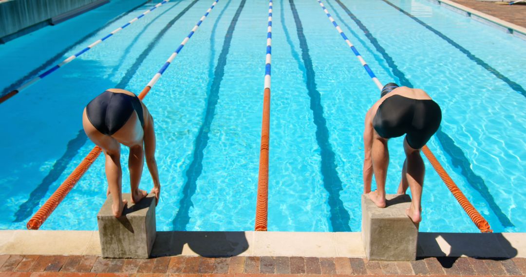 Two Swimmers Ready to Dive at Starting Blocks in Outdoor Pool - Free Images, Stock Photos and Pictures on Pikwizard.com