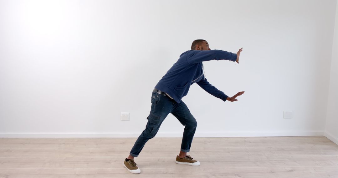 Casual Young Man Striking a Dynamic Pose in Minimalist Space