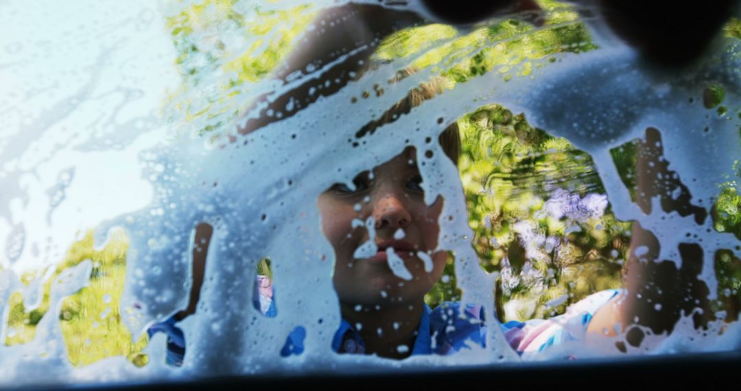 Child Cleaning Car Windshield with Soap Suds on Sunny Day - Free Images, Stock Photos and Pictures on Pikwizard.com