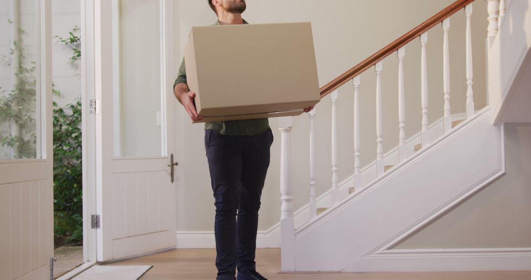 Man Carrying Cardboard Box on Staircase in New Home - Free Images, Stock Photos and Pictures on Pikwizard.com