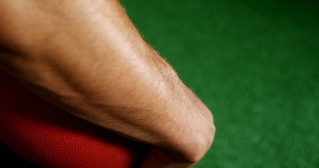 Close-Up of Arm Holding Red Ball Over Green Background - Free Images, Stock Photos and Pictures on Pikwizard.com