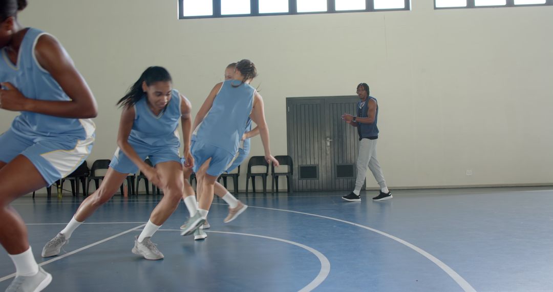 Diverse Women's Team Practicing Defensive Basketball Drills with Coach