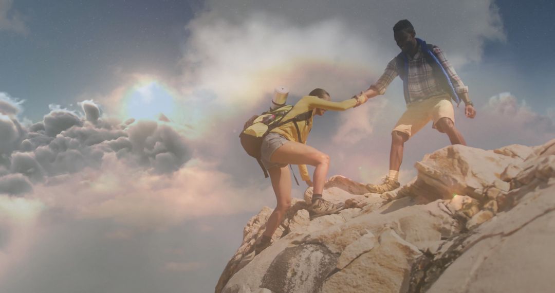 Hiker Assisting Partner on Mountain Top Against Scenic Sky