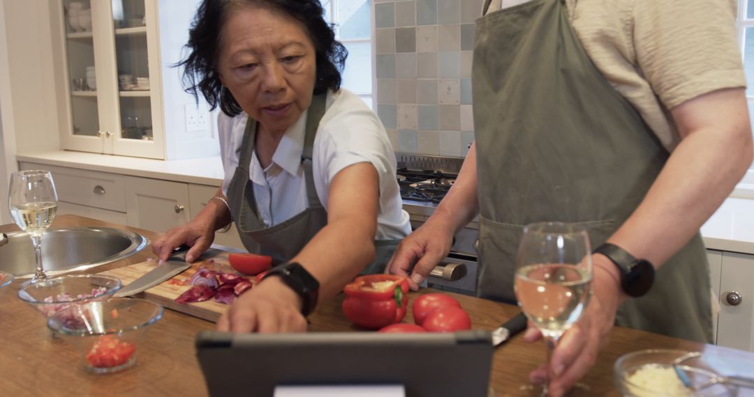 Senior Couple Following Recipe While Cooking Together at Home