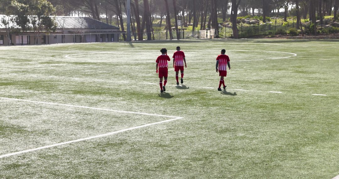 Youth Soccer Players Practicing Dribbling and Teamwork on Sunny Field