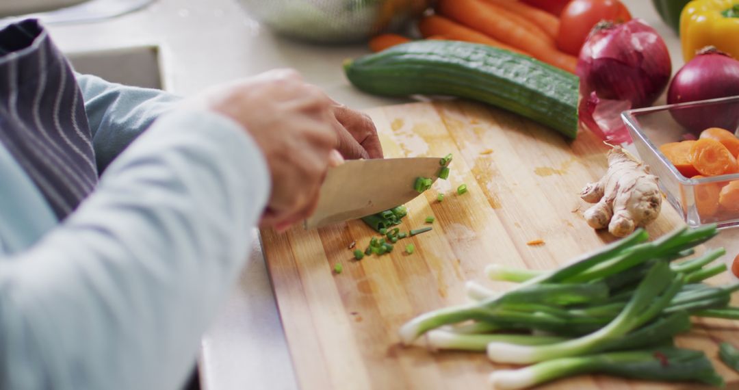 Person Chopping Green Onions on Wooden Cutting Board in Kitchen - Free Images, Stock Photos and Pictures on Pikwizard.com