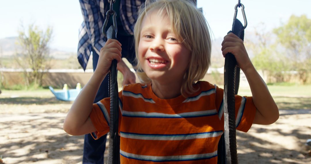 Smiling Child on Swing in Outdoor Playground on Sunny Day - Free Images, Stock Photos and Pictures on Pikwizard.com