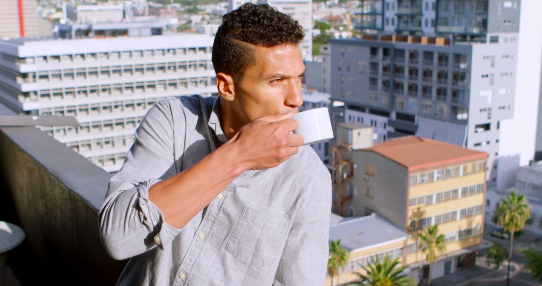 Young Man Drinking Coffee on City Balcony - Free Images, Stock Photos and Pictures on Pikwizard.com