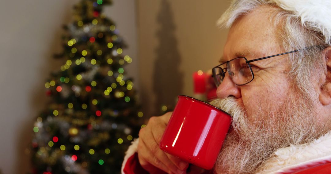 Santa Claus Drinking Hot Beverage Near Christmas Tree - Free Images, Stock Photos and Pictures on Pikwizard.com