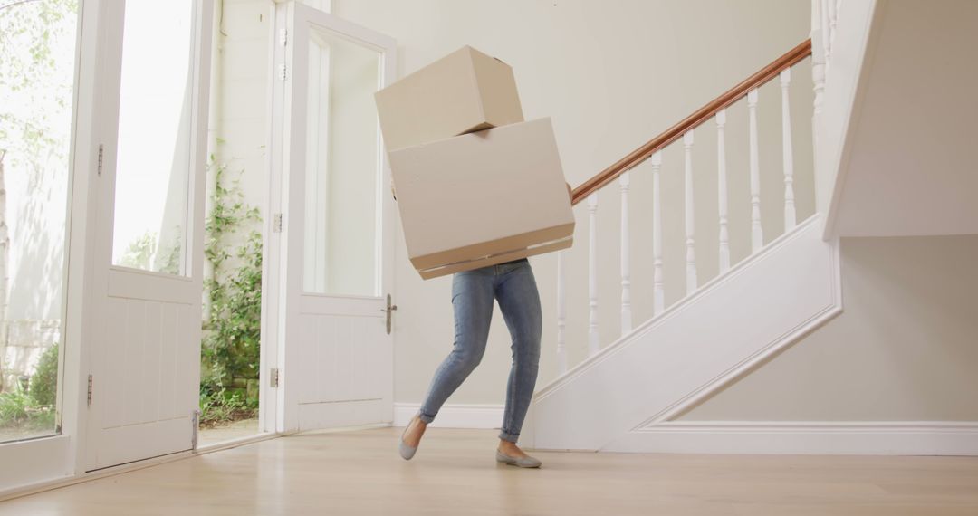 Person Struggling to Carry Boxes in Entryway - Free Images, Stock Photos and Pictures on Pikwizard.com