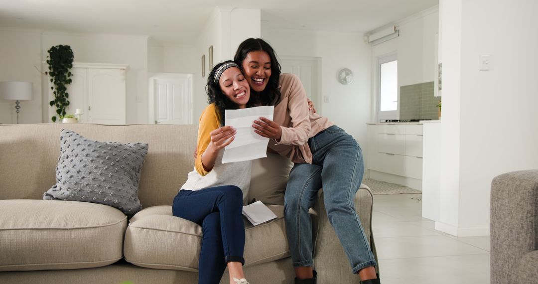 Two Women Sharing Exciting News while Reading Documents at Home