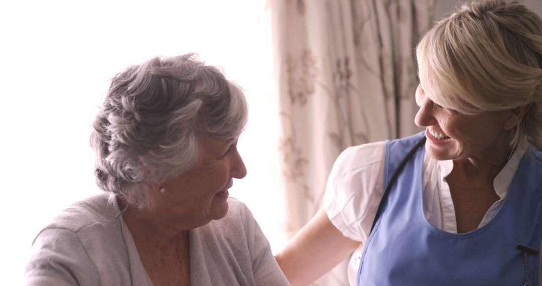 Elderly woman receiving care from a smiling caregiver - Free Images, Stock Photos and Pictures on Pikwizard.com