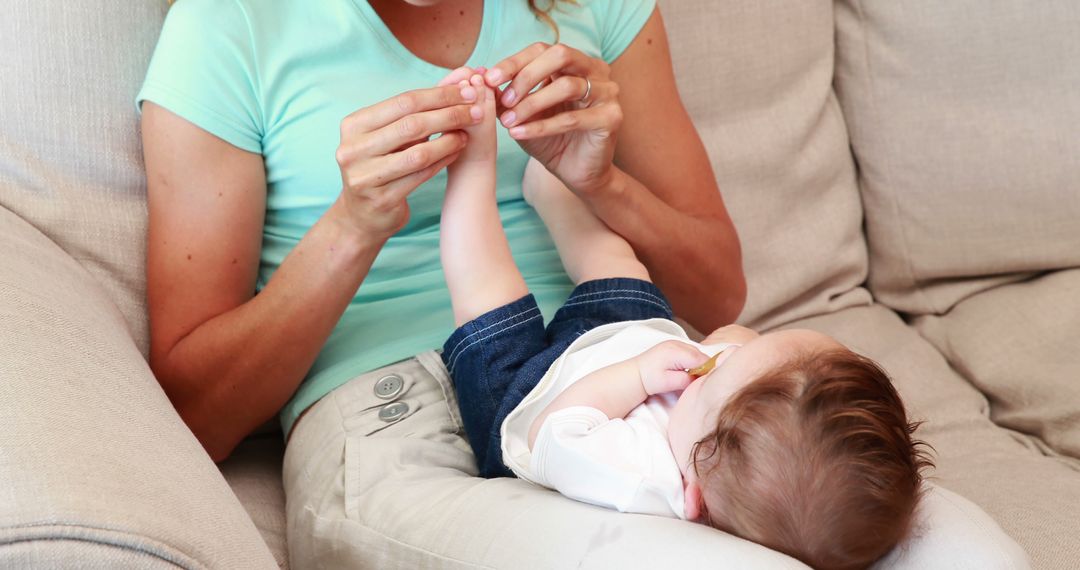 Mother Clipping Baby's Toenails on Comfortable Couch - Free Images, Stock Photos and Pictures on Pikwizard.com