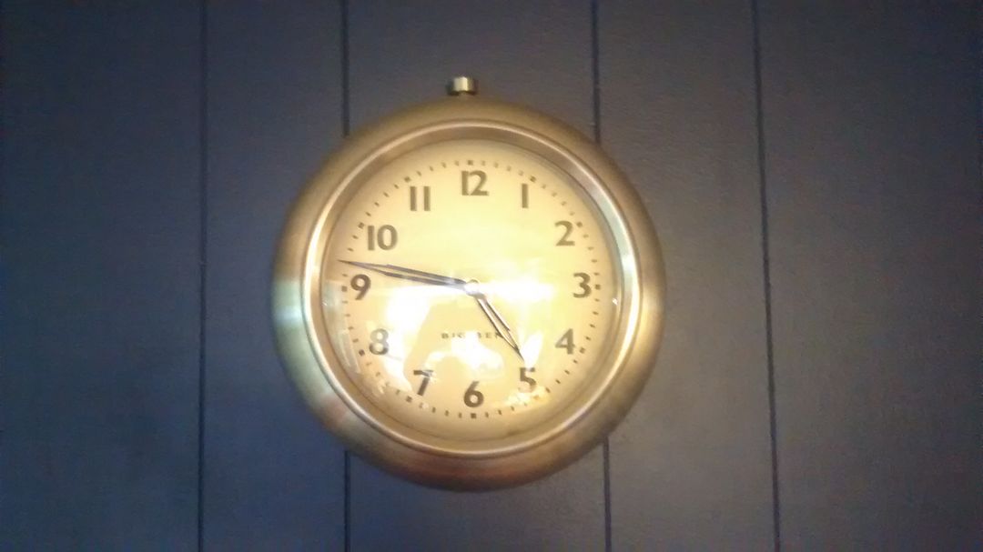Antique Brass Wall Clock Against Dark Blue Panel - Free Images, Stock Photos and Pictures on Pikwizard.com