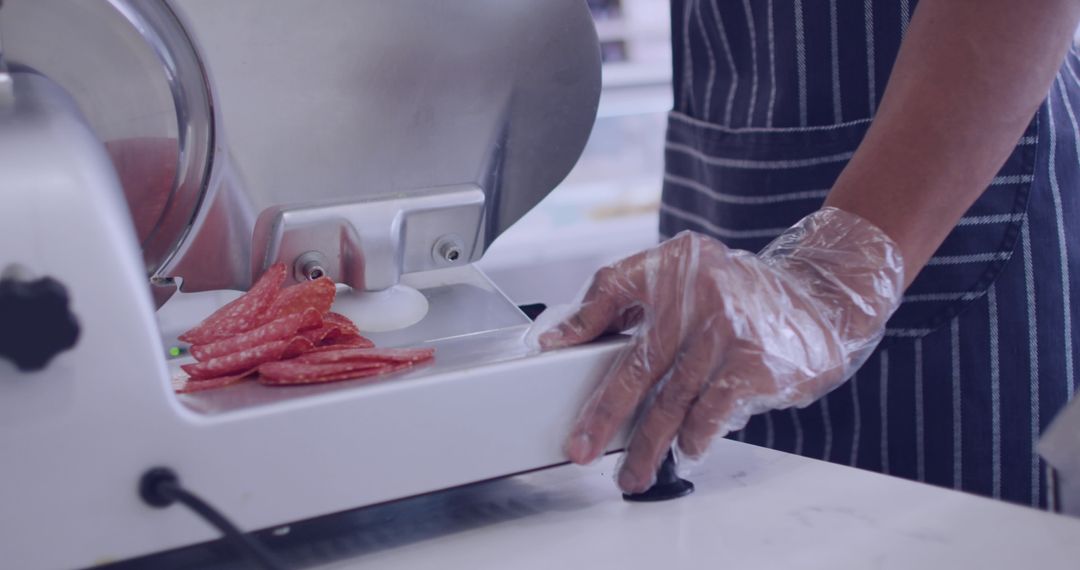 Deli Chef Slicing Salami with Professional Meat Slicer