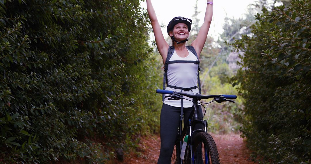 Happy Woman Celebrating Achievement During Mountain Bike Ride in Nature - Free Images, Stock Photos and Pictures on Pikwizard.com