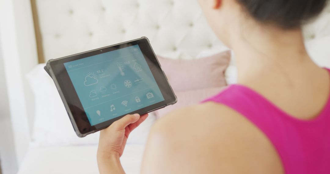 Woman Controlling Smart Home with Tablet in Bedroom