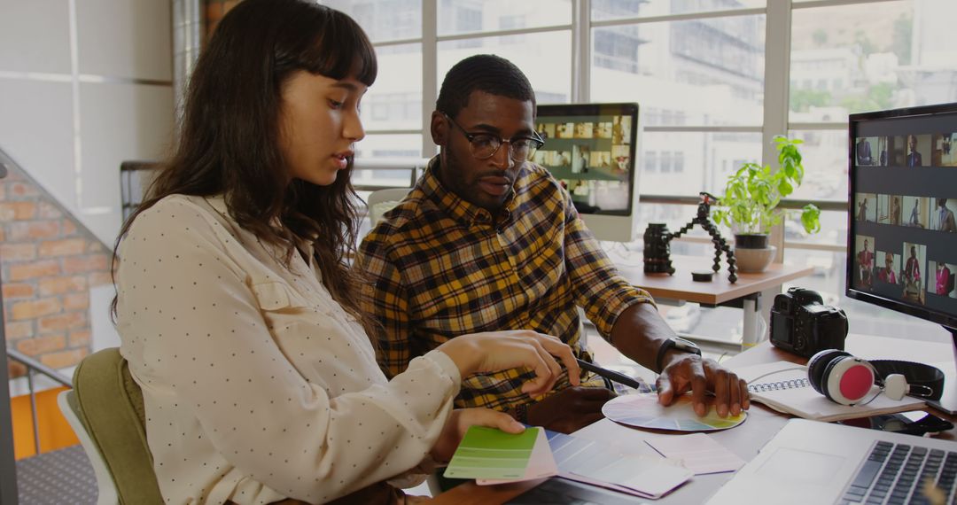 Diverse Graphic Designers Collaborating on Project in Modern Office