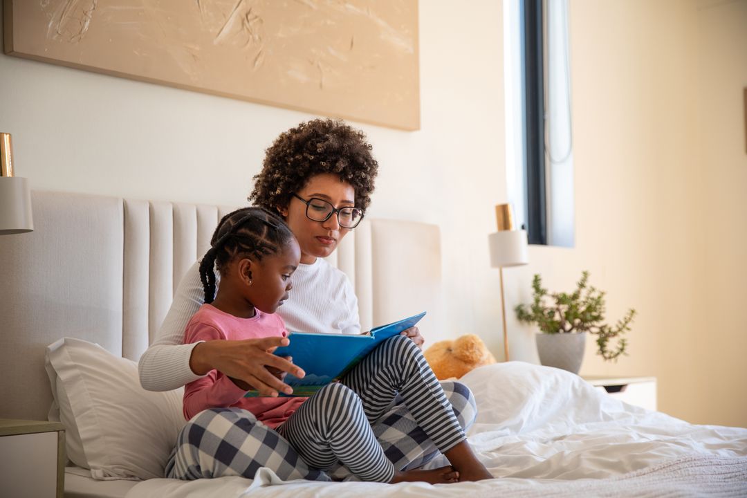 Mother and Daughter Enjoying Storytime in Bed