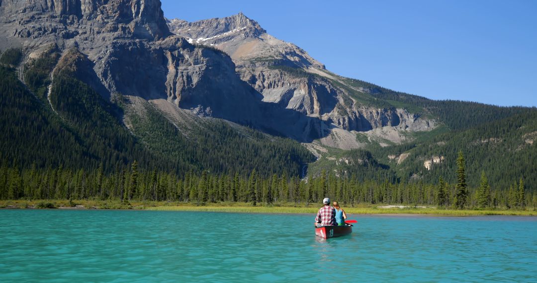 Man Canoeing on Turquoise Lake with Rocky Mountains in Background - Free Images, Stock Photos and Pictures on Pikwizard.com