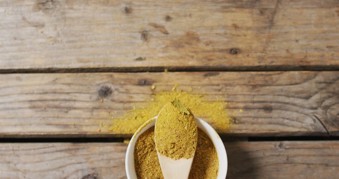 Wooden Spoon Filled with Ground Turmeric on Rustic Table - Free Images, Stock Photos and Pictures on Pikwizard.com