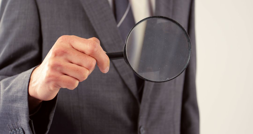 Businessman Showing Scrutiny with Magnifying Glass in Concept - Free Images, Stock Photos and Pictures on Pikwizard.com