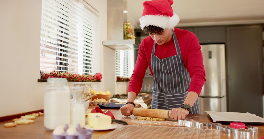 Man Preparing Christmas Cookies in Kitchen Wearing Santa Hat - Free Images, Stock Photos and Pictures on Pikwizard.com