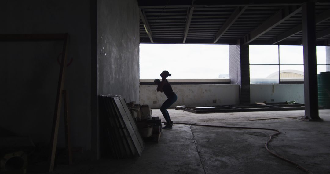 Silhouetted Worker Engaging in Construction Work Inside Building - Free Images, Stock Photos and Pictures on Pikwizard.com