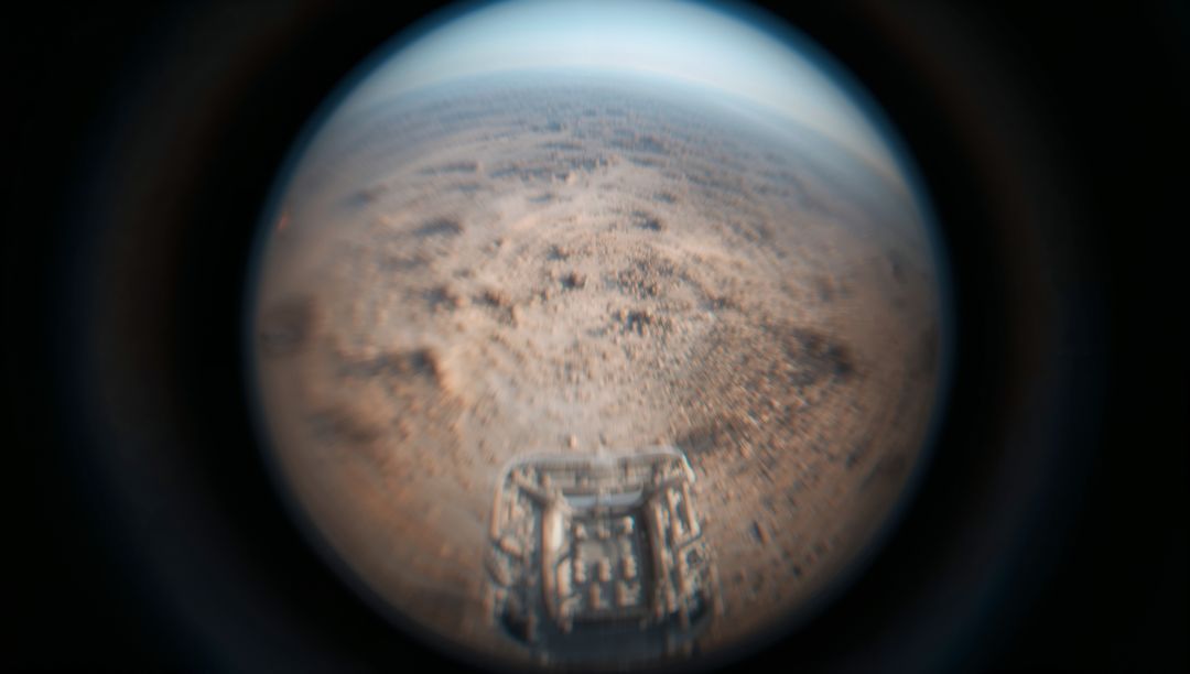 Capturing fisheye rover deck over dusty red plain with curved horizon and extraterrestrial landscape