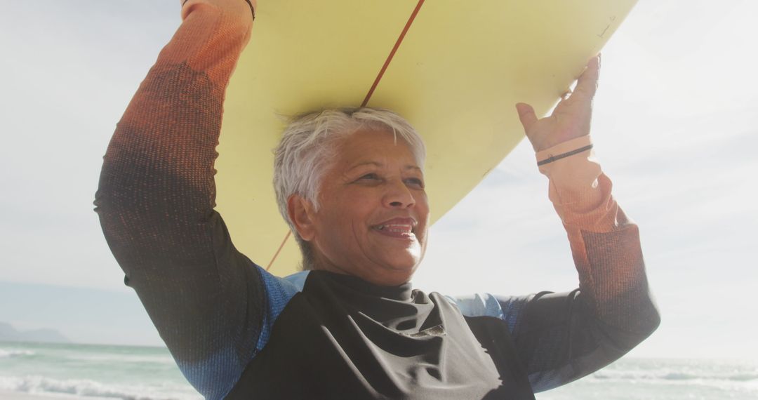 Senior Woman Joyful with Surfboard on Beach During Retirement