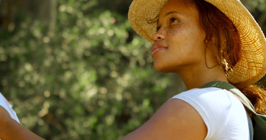 Young Woman Enjoying Sunny Day in Nature with Straw Hat - Free Images, Stock Photos and Pictures on Pikwizard.com