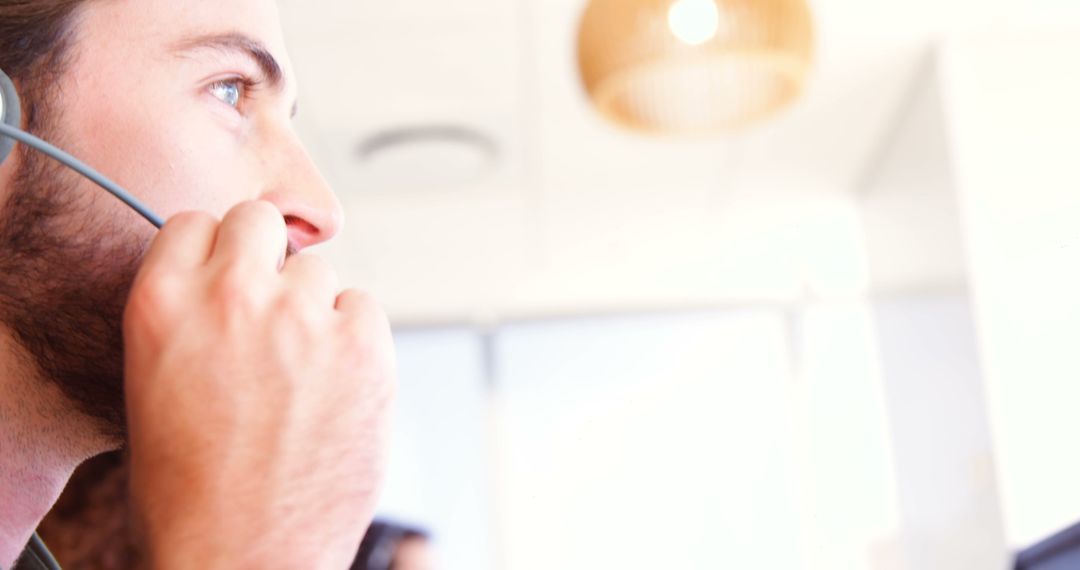 Caucasian Man Using Headset for Communication in Workplace