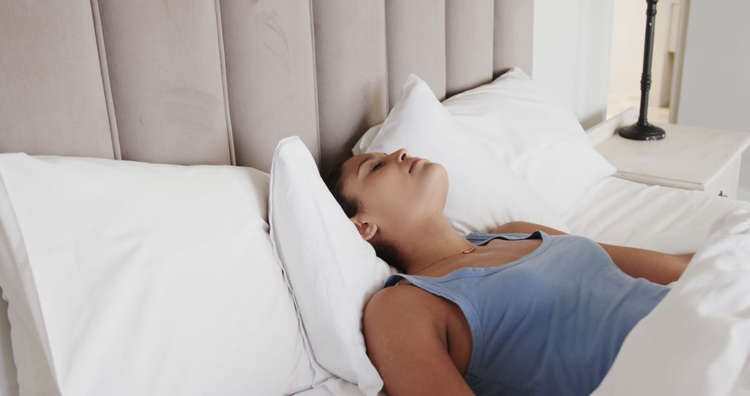 Woman resting on bed in modern bedroom - Free Images, Stock Photos and Pictures on Pikwizard.com