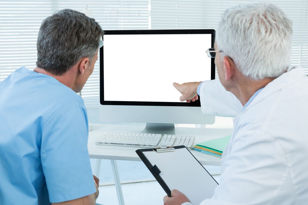 Surgeon and doctor discussing over personal computer - Free Images, Stock Photos and Pictures on Pikwizard.com