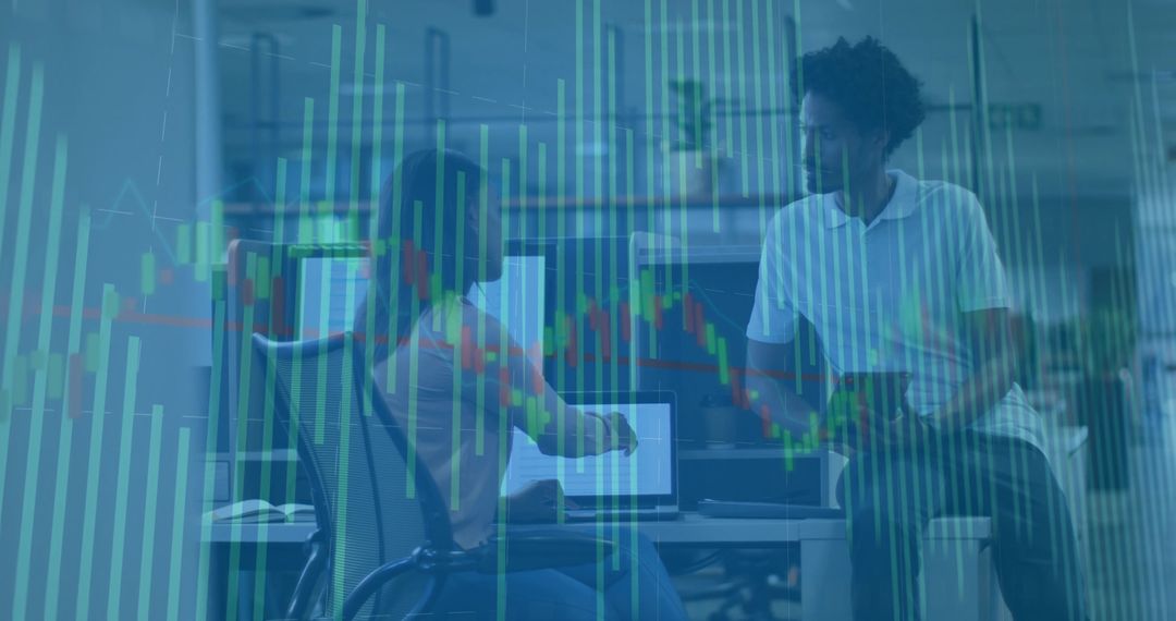 Collaborating analysts pointing at laptop with candlestick market overlay in open office
