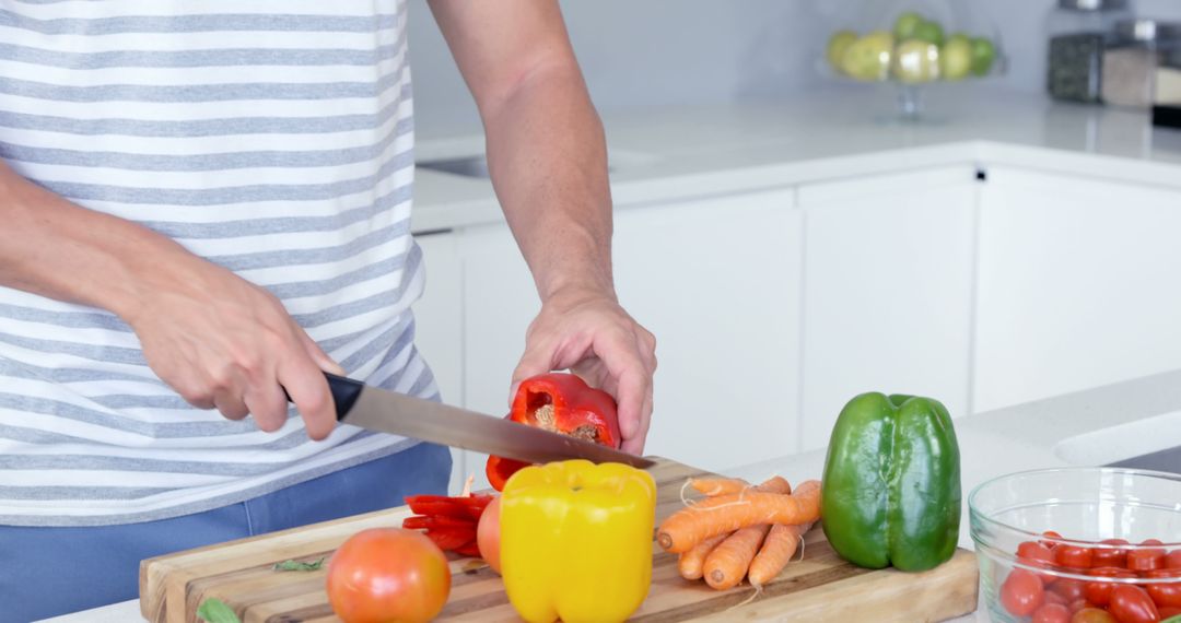 Person Chopping Colorful Vegetables on Wooden Cutting Board in Modern Kitchen - Free Images, Stock Photos and Pictures on Pikwizard.com