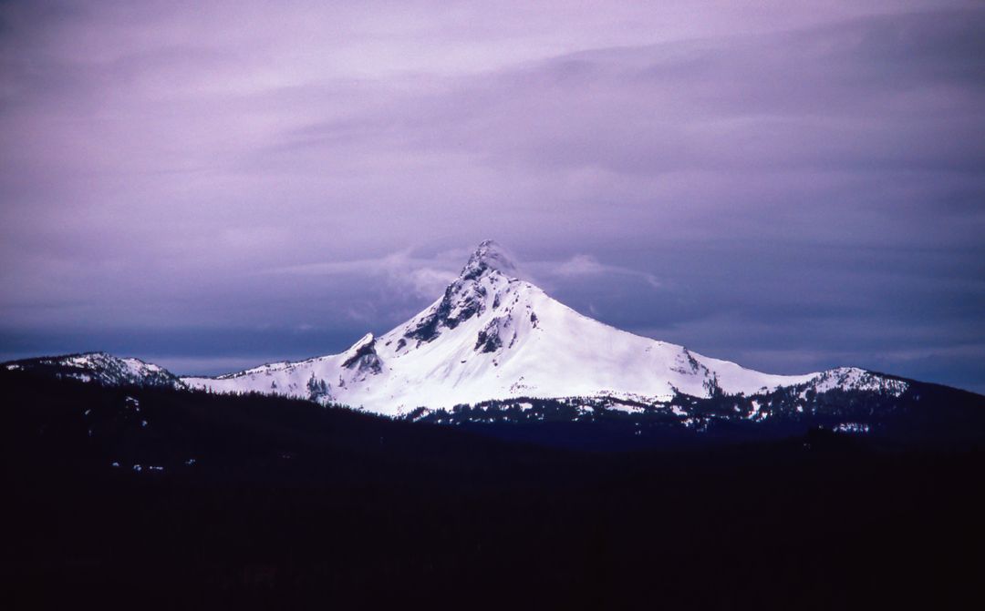 Snow-Covered Mountain Peak at Twilight with Overcast Sky - Free Images, Stock Photos and Pictures on Pikwizard.com